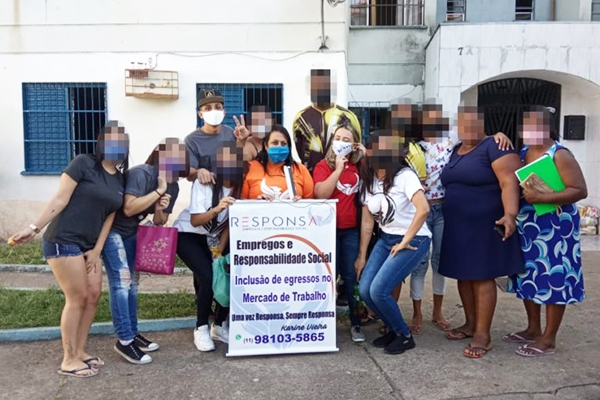 Aglaê no centro da foto, de camiseta laranja, segurando o banner – Foto: divulgação